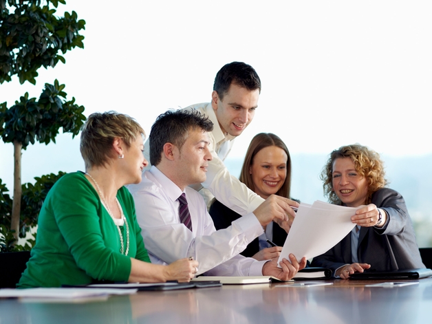 Grupo de funcionários conversando em uma grande mesa de reunião.