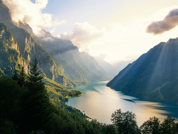 Lake surrounded by forested mountains.